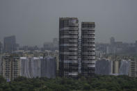 Twin high-rise apartment towers are seen before they are leveled to the ground in a controlled demolition in Noida, outskirts of New Delhi, India, Sunday, Aug. 28, 2022. The demolition was done after the country's top court declared them illegal for violating building norms. The 32-story and 29-story towers, constructed by a private builder were yet to be occupied and became India's tallest structures to be razed to the ground. (AP Photo/Altaf Qadri)