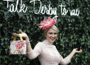 FILE - A woman wears a hat and poses for a picture during the 145th running of the Kentucky Derby horse race at Churchill Downs Saturday, May 4, 2019, in Louisville, Ky. The first Saturday in May is Derby Day with all its accompanying pageantry, including fancy hats. (AP Photo/Darron Cummings, File)
