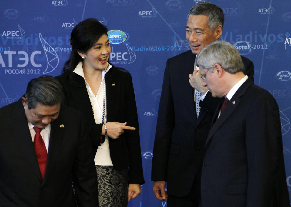 Thailand's Prime Minister Yingluck Shinawatra, top left, chats with Singapore Prime Minister Lee Hsien Loong, top right as Indonesian President Susilo Bambang Yudhoyono, left, and Canadian Prime Minister Stephen Harper look on as they gather with other leaders for a group photo on the final day of the APEC summit in Vladivostok, Russia, Sunday, Sept. 9, 2012. (AP Photo/Vincent Yu)