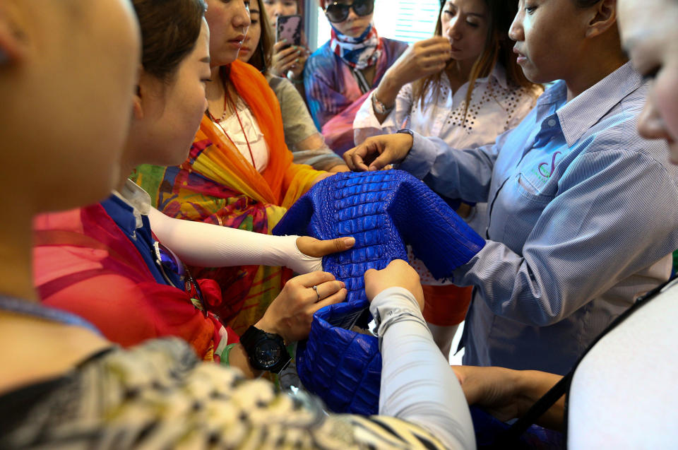 <p>Chinese tourists touch a dyed crocodile skin at Sriracha Crocodile Farm in Chonburi province, Thailand, June 20, 2017. (Photo: Athit Perawongmetha/Reuters) </p>