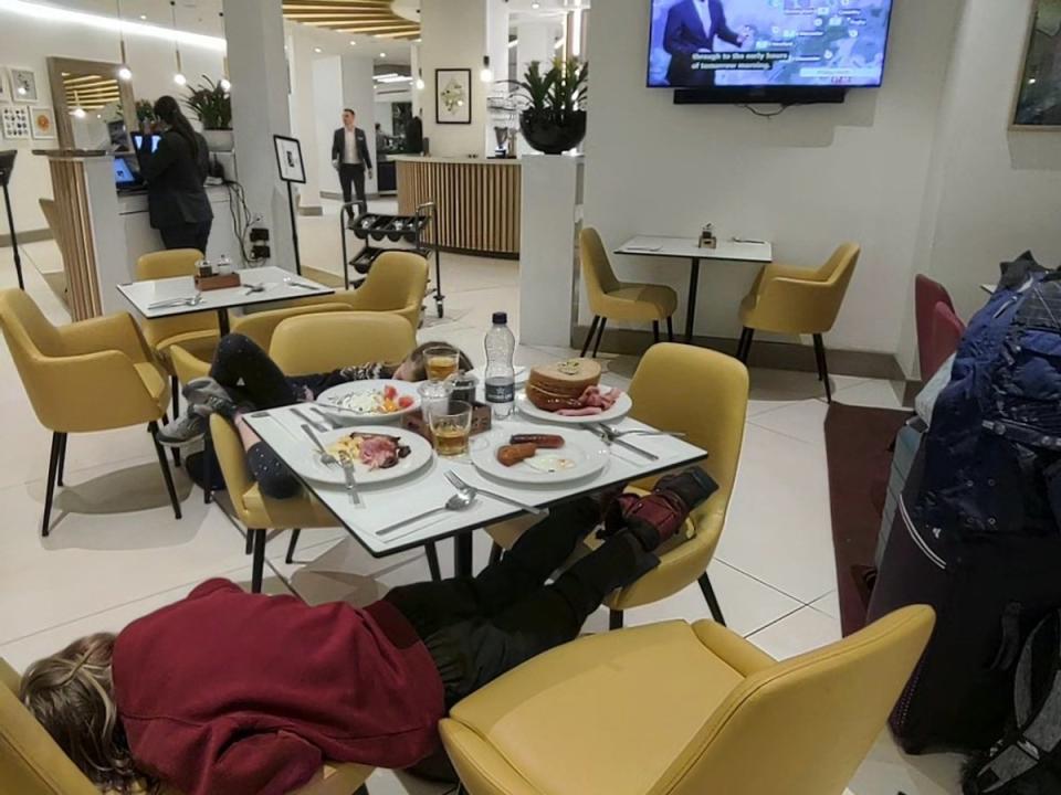 Children exhausted by the wait for an update on the cancelled EasyJet flight sleep at a breakfast restaurant (Tim Clark / SWNS)