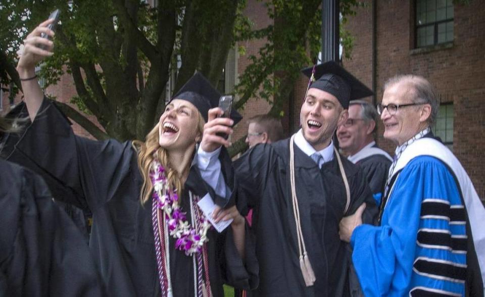 Business major Catherine Mooney- Myers and Kohl Meyer pose for a selfie with school president Ronald R. Thomas during graduation at University of Puget Sound on May 15, 2016.