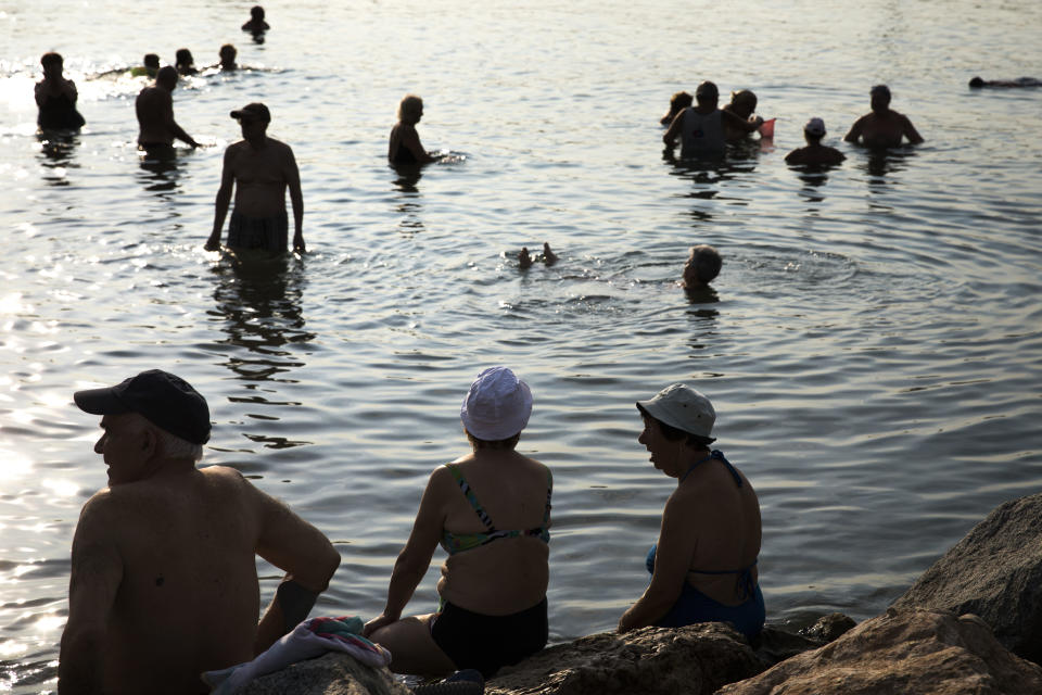 People refresh themselves on the beach during a hot summer day in Barcelona, Spain, Friday, Aug. 3, 2018. Hot air from Africa is bringing a heat wave to Europe, prompting health warnings about Sahara Desert dust and exceptionally high temperatures that could peak at 47 degrees Celsius (117 Fahrenheit) in Spain and Portugal. (AP Photo/Emilio Morenatti)