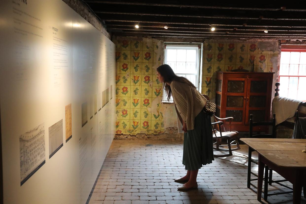 A visitor reads the names of the 13 enslaved individuals that were owned by the Davenport Family at the new Urban Enslaved exhibit at the Davenport House Museum. The Davenport House's preservation was the beginning of the Historic Savannah Foundation.