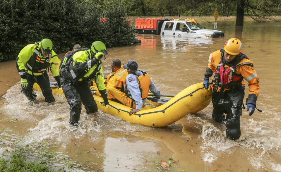 An Atlanta Public Works crew got caught in the Peachtree Creek overflow onto the flooded Woodward Way as they were delivering Road Block equipment and had to be rescued by the Atlanta Fire Rescue's Swift Water Dive Team in Atlanta, Wednesday, April 5, 2017. Severe storms raking the Southeast unleashed one large tornado and more than a half dozen apparent twisters Wednesday, toppling trees, roughing up South Carolina's 'peach capital' and raining out golfers warming up for the Masters. (John Spink/Atlanta Journal-Constitution via AP)