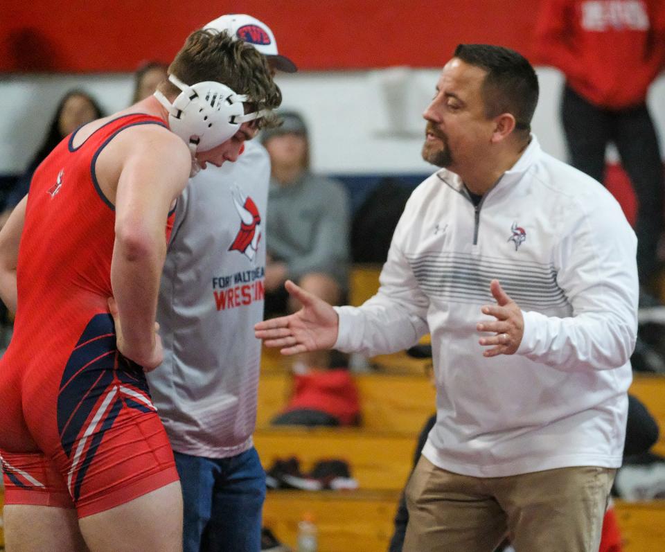 Fort Walton Beach wrestling coach Tobi Marez talks with Carter Tobik in a break during the Beast of the Beach wrestling tournament at Fort Walton Beach High School.