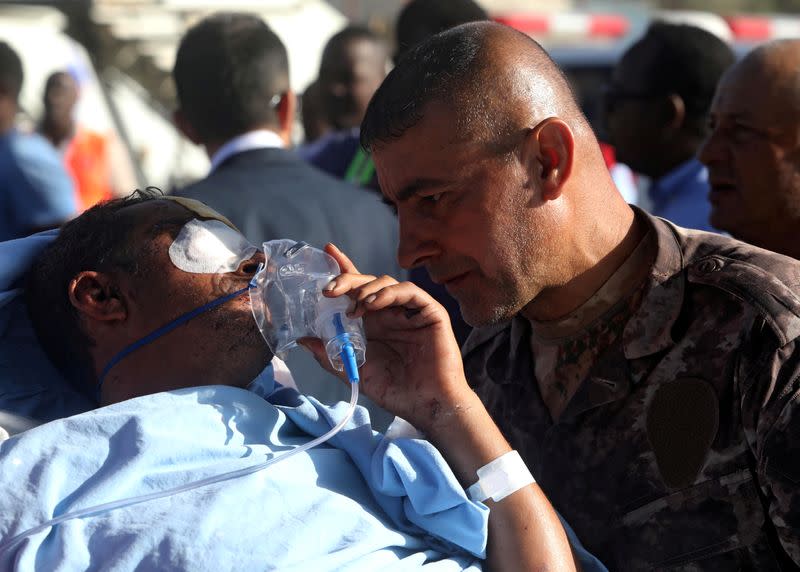 A Turkish military officer talks to a Turkish worker injured in an explosion in Afgoye town, before he boards a Turkish military cargo plane at the Aden Abdulle International Airport in Mogadishu