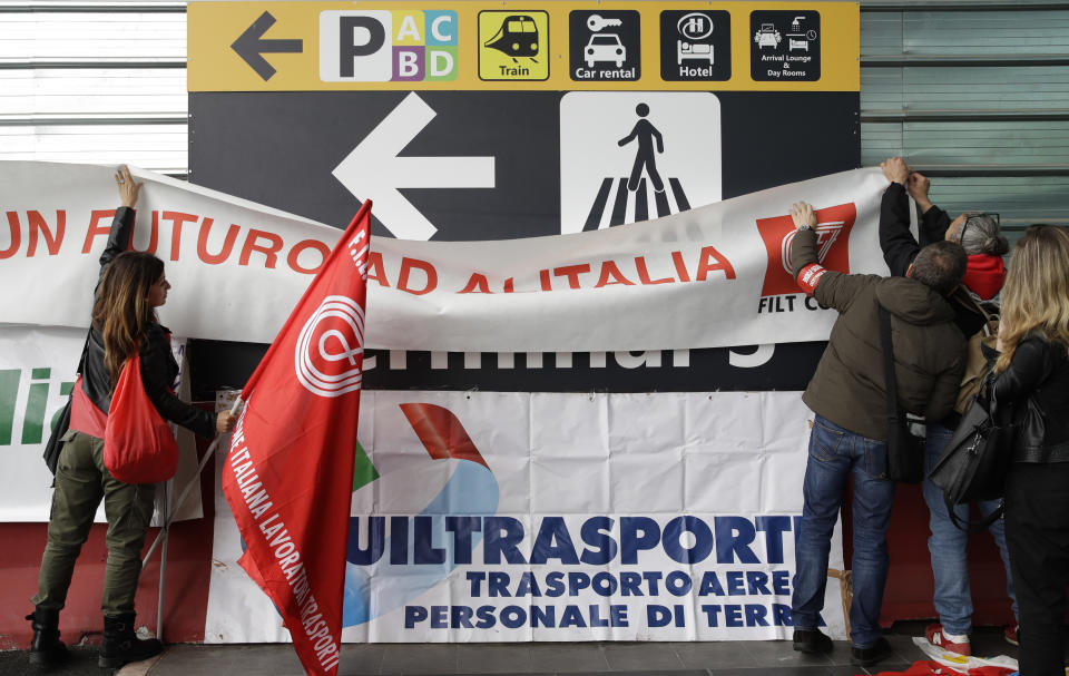 Striking Alitalia workers place unions flags and banners, at the Fiumicino airport in Rome Tuesday, May 21, 2019. Alitalia workers are on a 24 hours strike since Monday night. (AP Photo/Alessandra Tarantino)