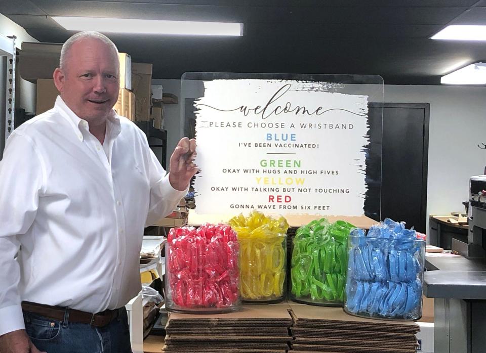 Ron Pollvogt, co-owner of The Elation Factory Co., in Houston, stands near his company's social distancing event kit, which provides attendees with a series of rubber band choices and signage that explains what each color means.