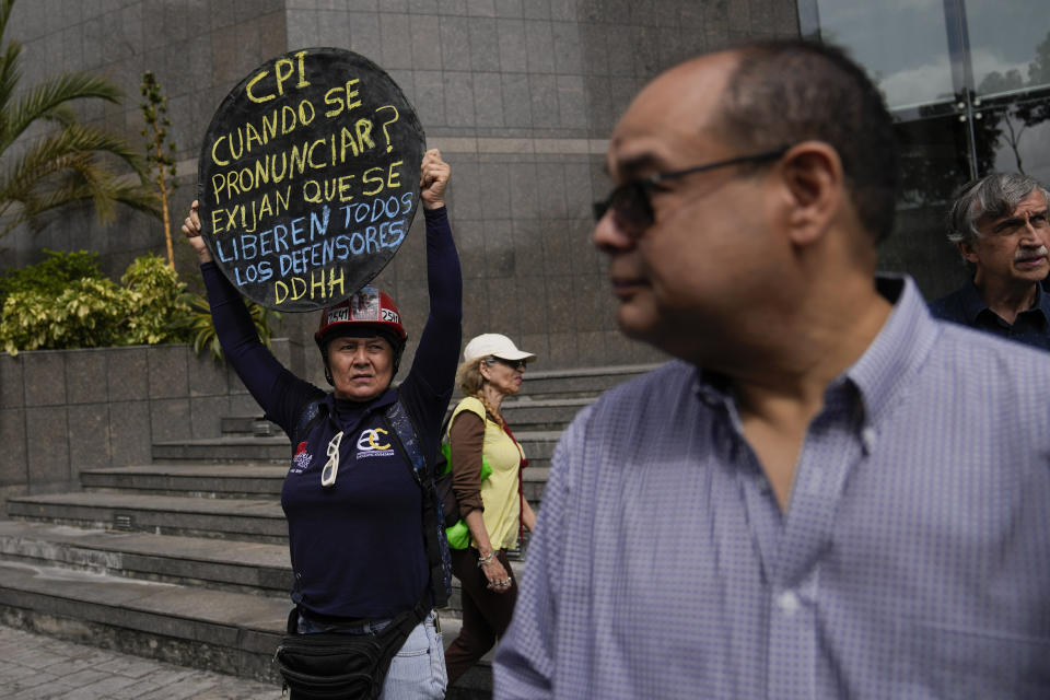 A protester holds up a sign that reads in Spanish "CPI (International Criminal Court) when will you speak out? Demand the release of all human rights defenders!" on the sidelines of a press conference about the previous week's detention of Human Rights lawyer and activist Rocio San Miguel, outside office of the UN Development Program (PNUD) in Caracas, Venezuela, Wednesday, Feb. 14, 2024. Rocio San Miguel is accused by the government of terrorism for allegedly plotting to kill President Nicolas Maduro. (AP Photo/Ariana Cubillos)