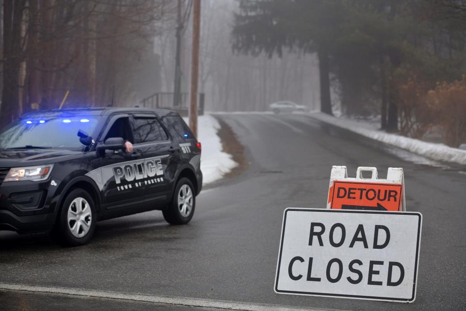 A Paxton police officer sits in a cruiser Sunday at Asnebumpskit Road. A short stretch of the road was closed due to a state police investigation.