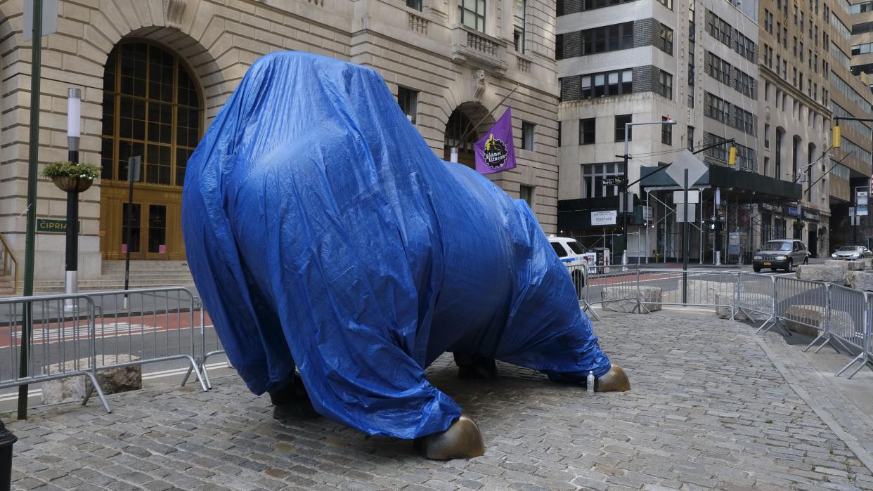 The "Charging Bull" statue is seen covered with blue tarp Sunday, July 5, 2020. The statue located on Bowling Green is a symbol of capitalism and is being protect against vandals, although no NYPD Officers or patrol car were present near the statue.