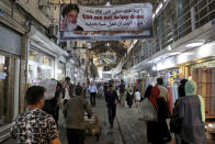 People walk at the old main bazaar in Tehran, Iran, Sunday, June 23, 2019. The most-visible place to see the effect of the economic hardship most face comes from walking by any money-exchange shop. As the U.S. piles sanction after sanction on Iran, it’s the average person who feels it the most. At the time of the nuclear deal, Iran’s currency traded at 32,000 rials to $1. Today, it costs over 130,000 rials for one U.S. dollar. (AP Photo/Ebrahim Noroozi)