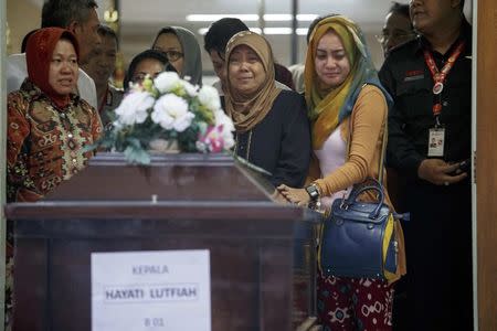 The mother (2nd R) and other family members of Hayati Lutfiah, a passenger of AirAsia QZ8501, cry upon receiving her remains at Bhayankara Hospital in Surabaya January 1, 2015. REUTERS/Athit Perawongmetha