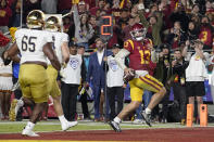 Southern California quarterback Caleb Williams, right, runs in for a touchdown as Notre Dame defensive lineman Chris Smith, left, and safety Justin Walters defend during the first half of an NCAA college football game Saturday, Nov. 26, 2022, in Los Angeles. (AP Photo/Mark J. Terrill)