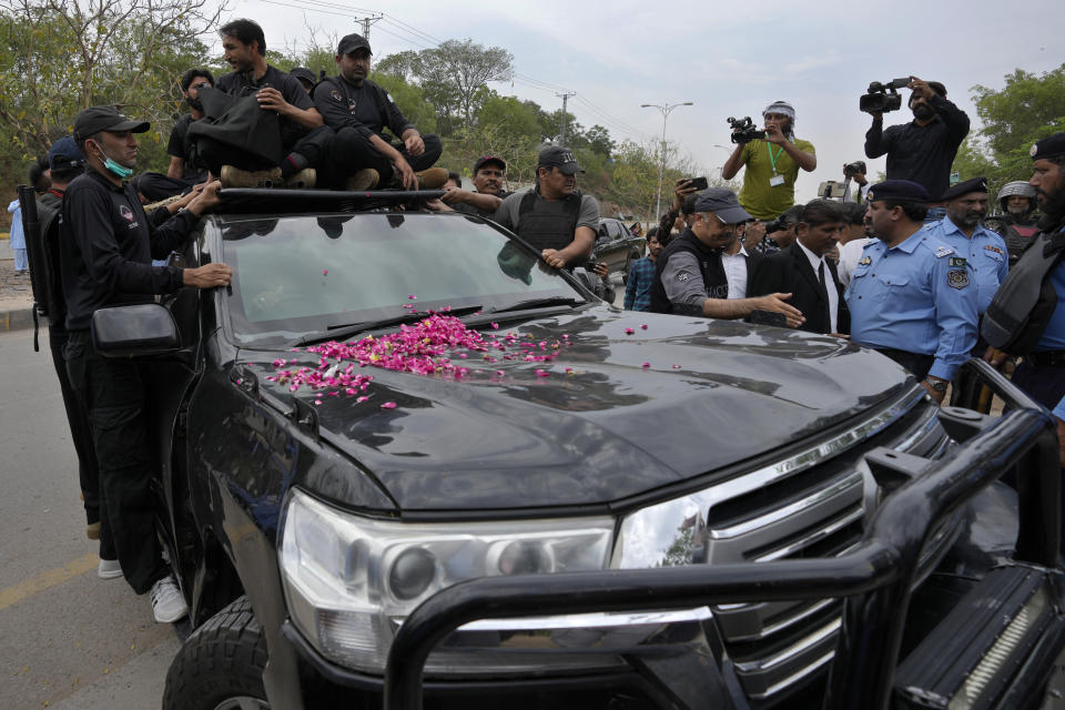 Security personnels secure a vehicle carrying the Pakistan's former Prime Minister Imran Khan arrives to appear in a court, in Islamabad, Pakistan, Tuesday, May 23, 2023. Khan on Tuesday pressed his legal battle before a court in the capital, Islamabad, which granted him protection from arrest until early next month in several cases where he faces terrorism charges for inciting violence. (AP Photo/Anjum Naveed)