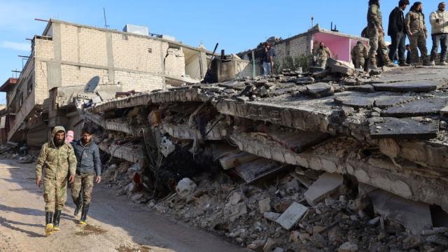 Rescatistas sirios se reúnen sobre los escombros de un edificio derrumbado en la ciudad de Jindires, en la parte rebelde de la provincia de Alepo.