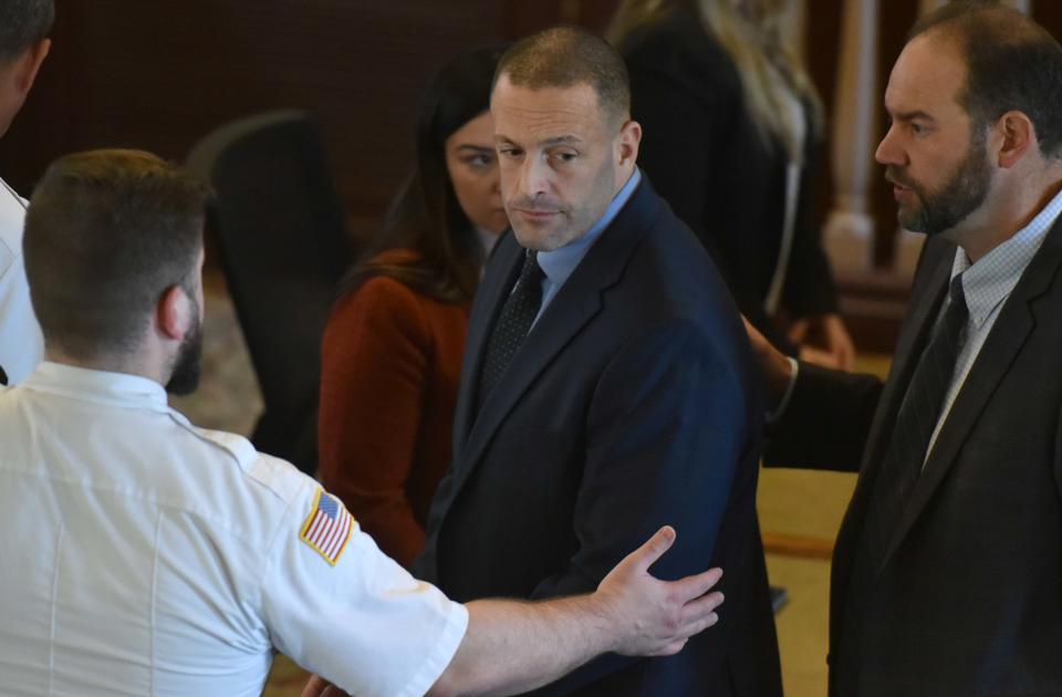 Eli Perry is escorted back to the lock up in Barnstable Superior Court on Friday afternoon after being found guilty of manslaughter of his father Raymond Perry by a jury on Friday afternoon. His attorney Eduardo Masferrer is at right.