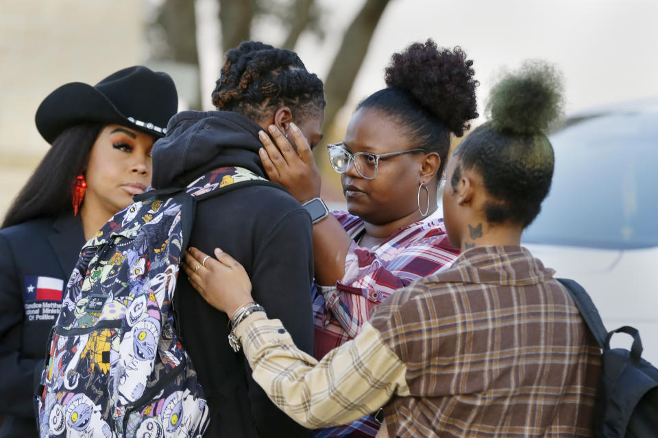 Darryl George, center left, a 17-year-old junior, and his mother Darresha George, center right, share words of encouragement before walking across the street to go into Barbers Hill High School after Darryl served a 5-day in-school suspension for not cutting his hair Monday, Sept. 18, 2023, in Mont Belvieu. (AP Photo/Michael Wyke)