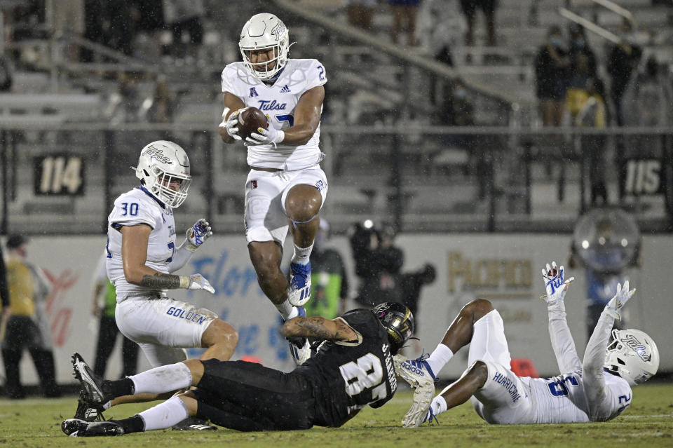 Tulsa linebacker Zaven Collins (23) intercepts a pass intended for Central Florida wide receiver Jacob Harris (87) after the ball was deflected by Tulsa linebacker Justin Wright (30) and cornerback Akayleb Evans (26) during the first half of an NCAA college football game Saturday, Oct. 3, 2020, in Orlando, Fla. (AP Photo/Phelan M. Ebenhack)