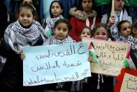 <p>Students hold placards as they protest the US President Donald Trump’s intention to recognize Jerusalem as Israels capital, at Faisal Husseini school in Ramallah, West Bank on Dec. 6, 2017. (Photo: Issam Rimawi/Anadolu Agency/Getty Images) </p>