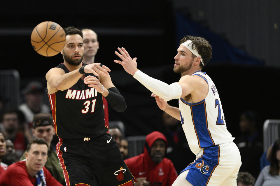 Miami Heat guard Max Strus (31) passes the ball past Washington Wizards forward Corey Kispert (24) during the first half of an NBA basketball game Friday, April 7, 2023, in Washington. (AP Photo/Nick Wass)