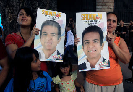 Supporters hold up posters of Salvador Nasralla, presidential candidate for the Opposition Alliance Against the Dictatorship, outside a polling station during the presidential election in Tegucigalpa, Honduras November 26, 2017. REUTERS/Jorge Cabrera