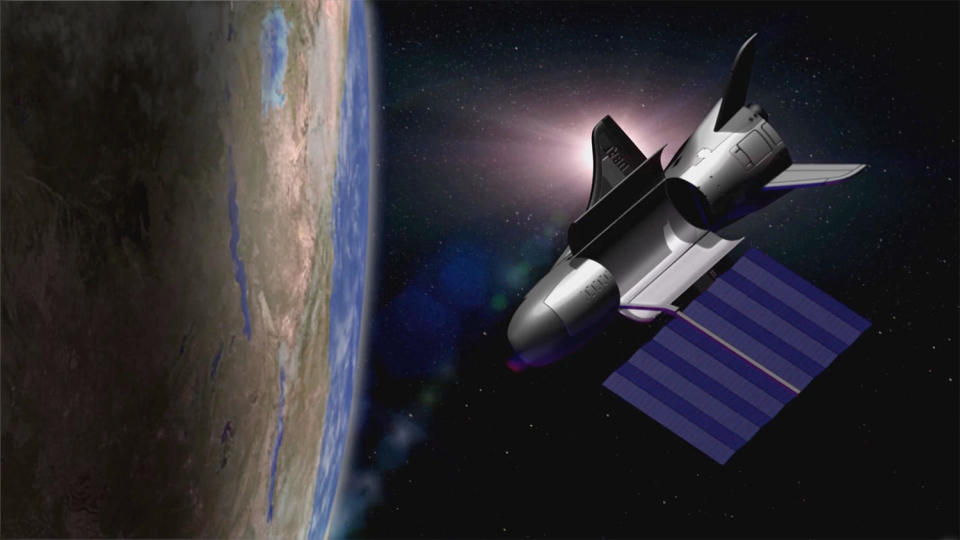 Artist's impression of the X-37B spaceplane in orbit with a solar array extending from its compact payload bay.  / Credit: Boeing