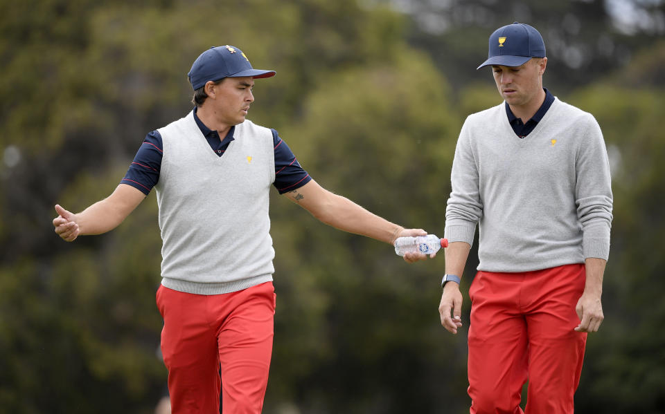 Los jugadores del equipo Estados Unidos, Rickie Fowler (izquierda) y Justin Thomas, hablan durante un partido a cuatro en la Copa Presidentes, en el Royal Melbourne Golf Club, en Melbourne, el 14 de diciembre de 2019. (AP Foto/Andy Brownbill)