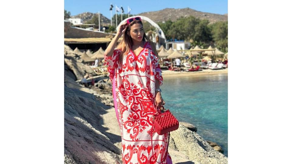 Farah El Kadhi in a red and white kimono on rocks next to the sea