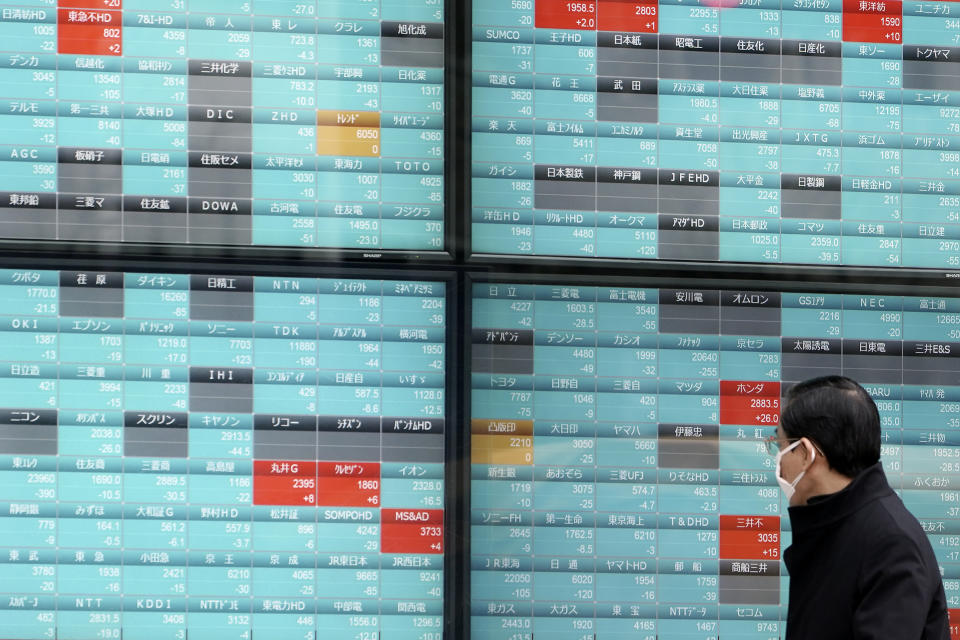 A man looks at an electronic stock board showing Japan's Nikkei 225 index at a securities firm in Tokyo Monday, Feb. 10, 2020. Asian stock markets slid Monday after China reported an uptick in new cases of its virus outbreak and analysts warned optimism the disease is under control might be premature. (AP Photo/Eugene Hoshiko)