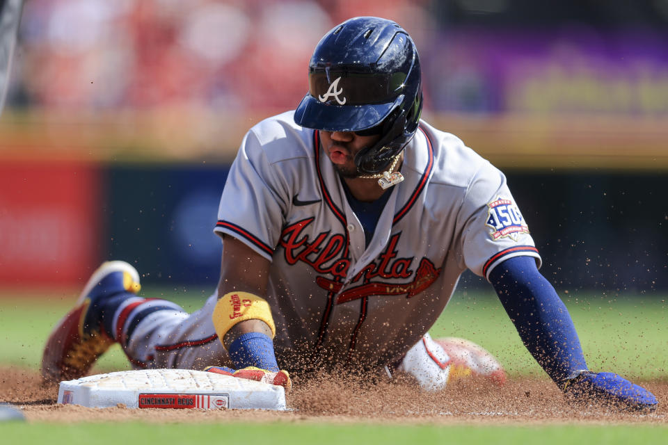 Atlanta Braves' Ronald Acuna Jr. slides safely into third base during the third inning of a baseball game against the Cincinnati Reds in Cincinnati, Saturday, June 26, 2021. (AP Photo/Aaron Doster)