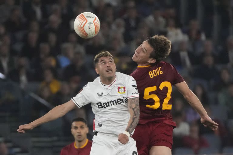 Edoardo Bove, que anotó el gol de Roma, lucha por la pelota con Exequiel Palacios, de Bayer Leverkusen, en el duelo en el estadio Olímpico.