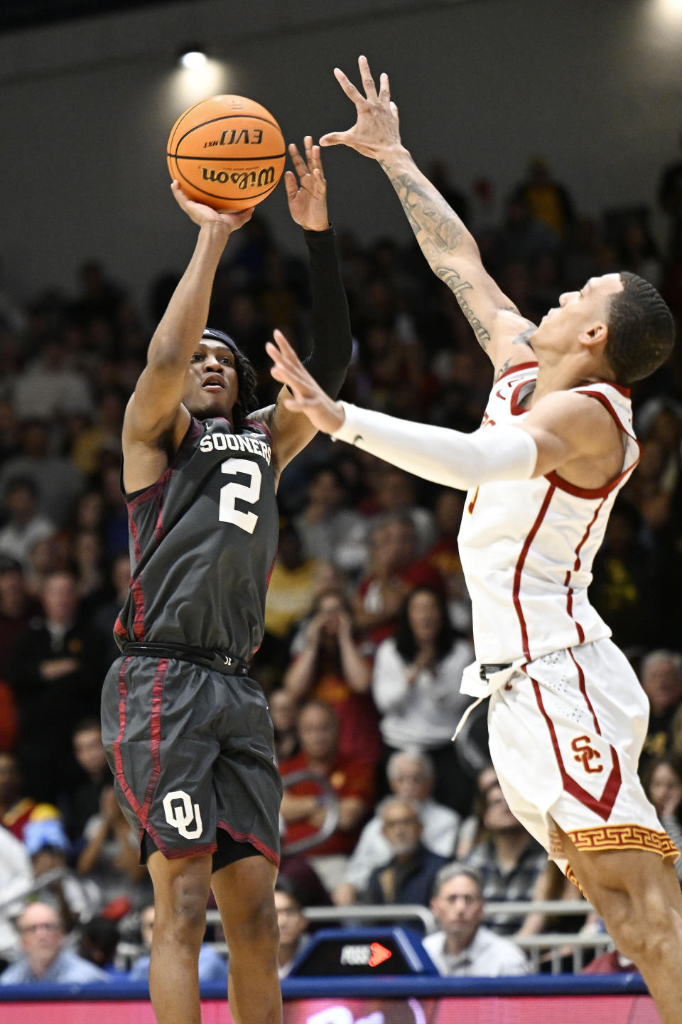 Oklahoma guard Javian McCollum (2) goes up to shoot over Southern California guard Kobe Johnson, right, as he sinks the final shot of an NCAA college basketball game Friday, Nov. 24, 2023, in San Diego. (AP Photo/Denis Poroy)