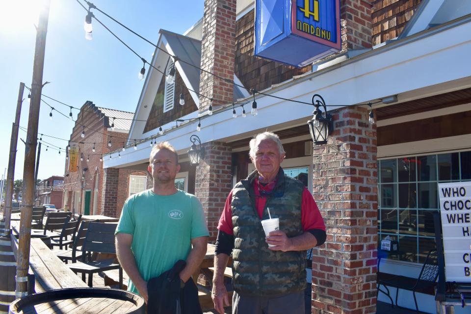 Rube McMullan, right, and his son, Barrett McMullan, stand in front of Wing & Fish Company in Shallotte. The pair is committed to restoring historic buildings to bring new businesses in.