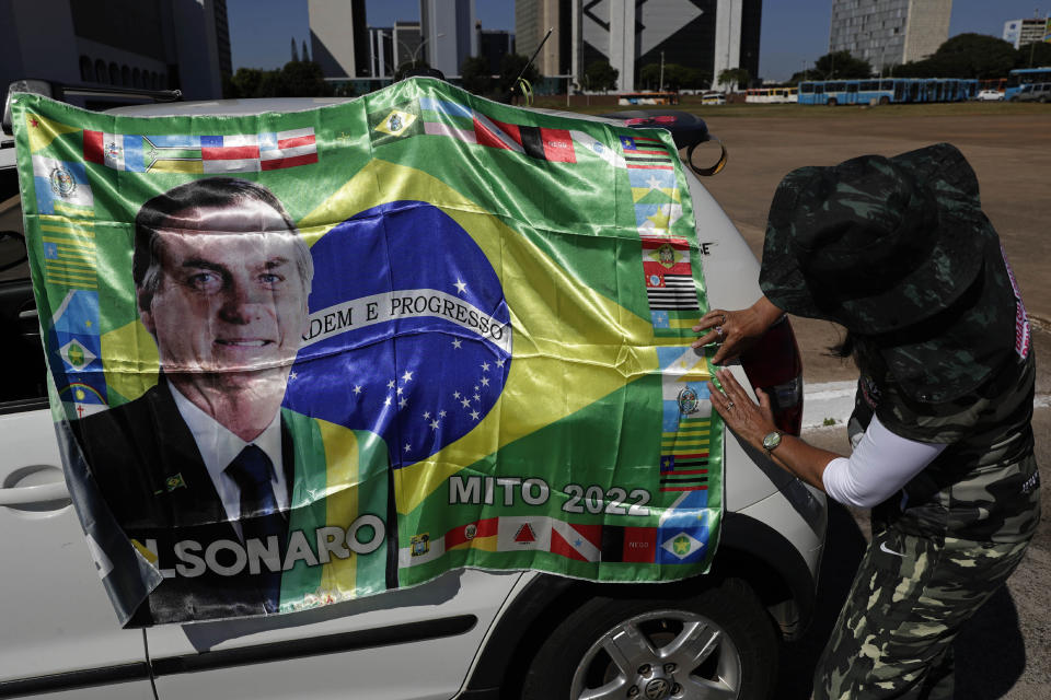 A supporter of Brazilian President Jair Bolsonaro places his image on a car during a gathering commemorating the 1964 military coup that established a decades-long dictatorship, in the Esplanade of Ministries in Brasilia, Brazil, Wednesday, March 31, 2021. The leaders of all three branches of Brazil’s armed forces jointly resigned the previous day following Bolsonaro’s replacement of the defense minister, causing widespread apprehension of a military shakeup to serve the president’s political interests. (AP Photo/Eraldo Peres)