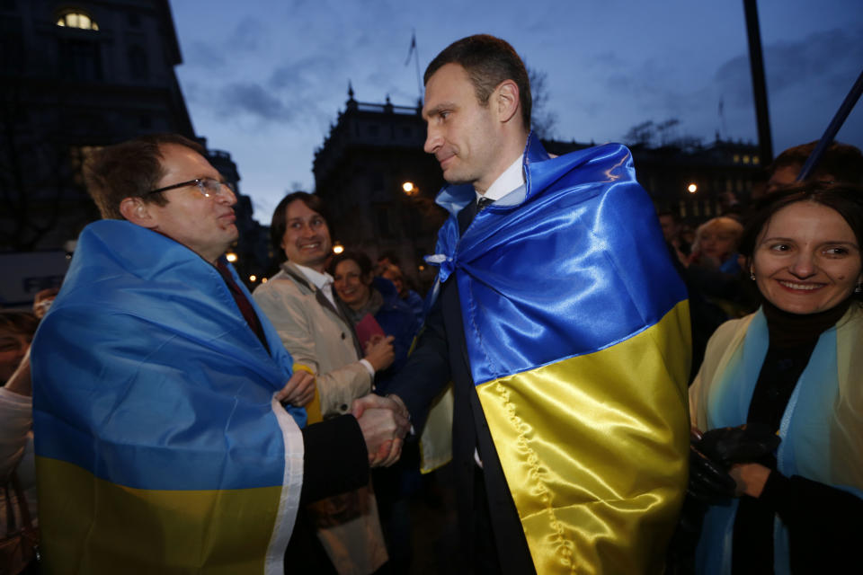 Ukraine's MP Vitali Klitschko, leader of the UDAR (Ukrainian Democratic Alliance for Reform) party, centre right, greets a protester outside 10 Downing Street in London after a meeting with British Prime Minister David Cameron and Foreign Secretary William Hague, Wednesday, March 26, 2014. (AP Photo/Sang Tan)