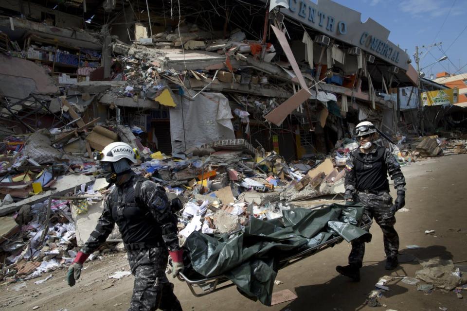 Rescue workers carry body bags