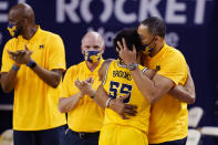 Michigan guard Eli Brooks (55) is hugged by coach Juwan Howard after being removed during the second half of the team's NCAA college basketball game against Michigan State, Thursday, March 4, 2021, in Ann Arbor, Mich. (AP Photo/Carlos Osorio)