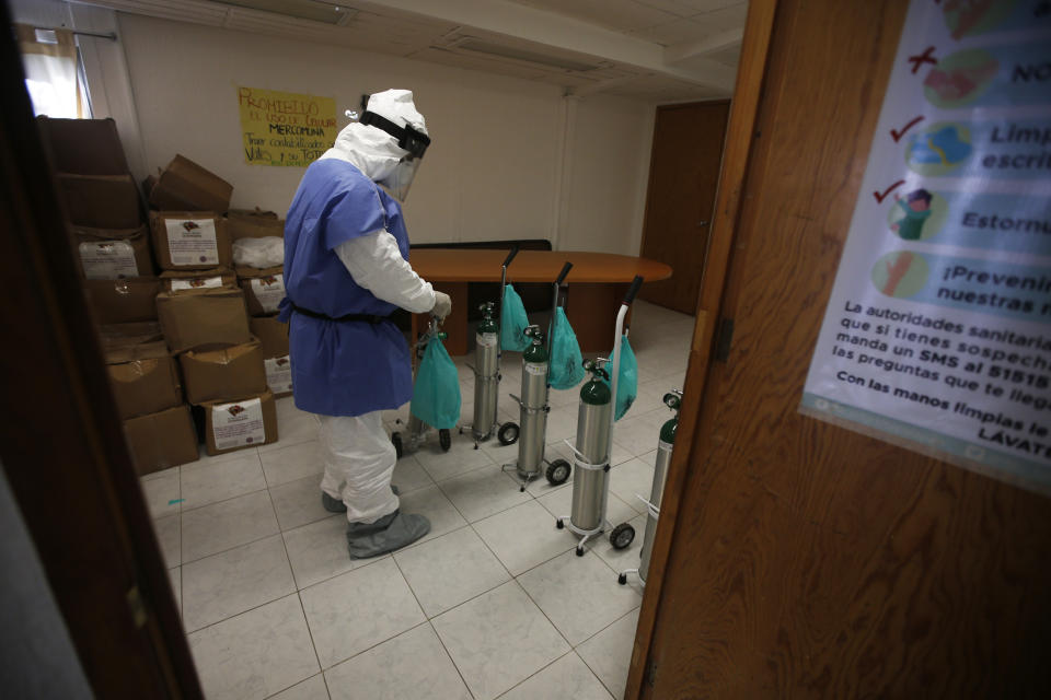 City worker Carlos Ruiz prepares tanks of oxygen for COVID-19 patients, in the Iztapalapa borough of Mexico City, Friday, Jan. 15, 2021. The city offers free oxygen refills for COVID-19 patients. (AP Photo/Marco Ugarte)