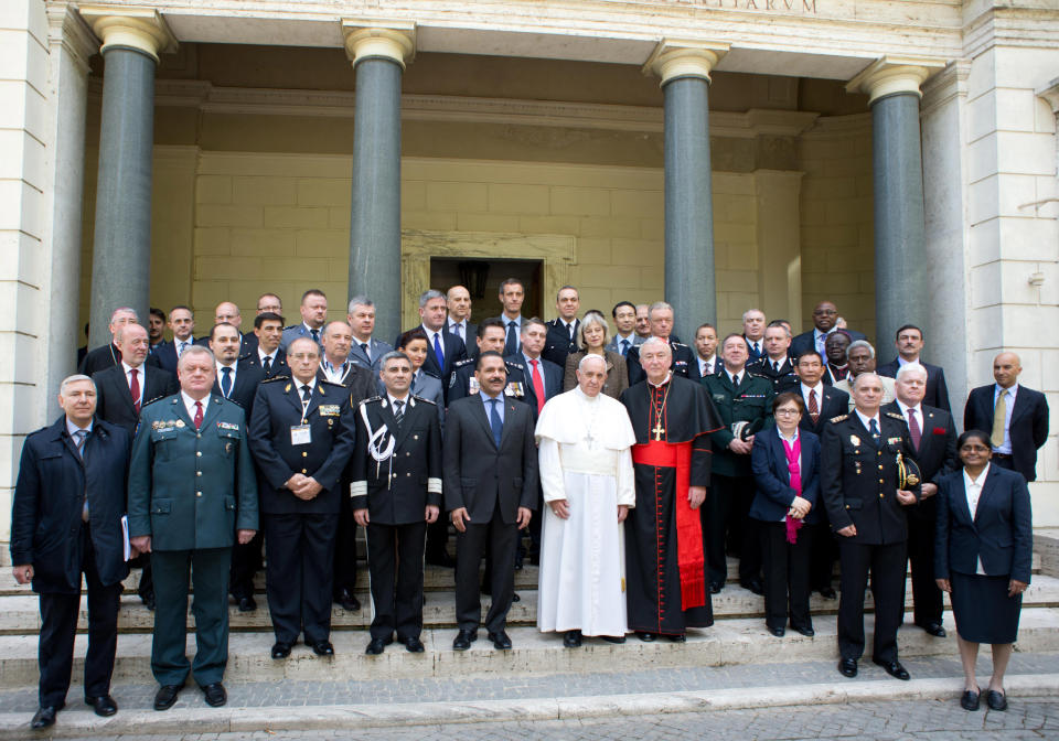 In this photo released by Vatican newspaper L'Osservatore Romano Pope Francis poses for a photo with participants in a conference about the human trafficking, at the Vatican, Thursday, April 10, 2014. Pope Francis has denounced human trafficking as a crime against humanity after meeting with four women who were forced into prostitution. Francis attended a Vatican conference Thursday of church workers, charity representatives and police chiefs from 20 nations, who pledged greater cooperation to encourage victims of trafficking and slavery to come forward. (AP Photo/L'Osservatore Romano)