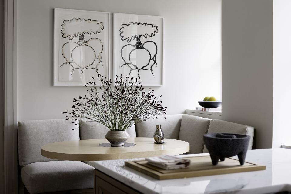 In the apartment's kitchen, de Cárdenas designed a breakfast nook with soft taupe upholstery and a warm wood table, flanked by a pair of black-and-white prints by Bob Stanley. Work by Lynn Roylance, Gene Davis, Amy Genser, and Rainer Gross (curated by Elizabeth Weiner Gallery) dots the apartment. "The art we used is by artists from all over working in all different styles," notes the designer. "The works are all dynamic in their own right and give the apartment a cosmopolitan vibe, and ultimately the appeal of the Upper West Side is this idea of a New York, intellectual, well-read, well-traveled life."