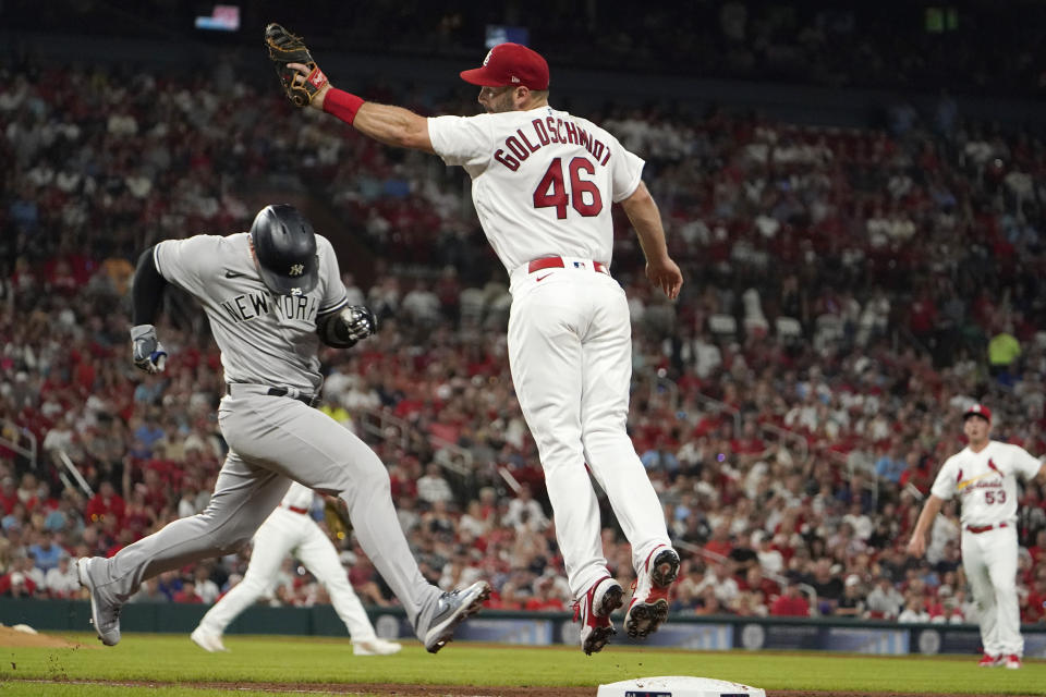 New York Yankees' Gleyber Torres, left, avoids the tag from St. Louis Cardinals first baseman Paul Goldschmidt (46) while reaching base on an RBI single during the fifth inning of a baseball game Friday, Aug. 5, 2022, in St. Louis. (AP Photo/Jeff Roberson)