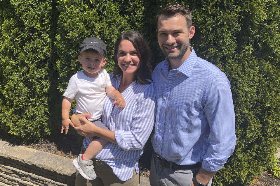 Maddy, center, and Brian Bascom, right, both members of the Millennial generation, as they pose for a photo with their son, Jack in their backyard in Cincinnati. Millennials, who became young adults in this century, are getting socked again as they were still recovering from the Great Recession. (AP Photo/Dan Sewell)