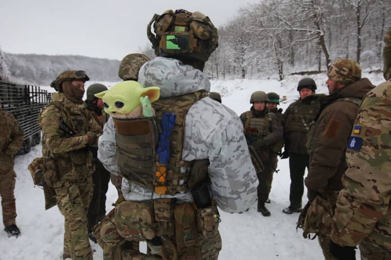 A soldier has a baby Yoda toy in the pocket of his bulletproof vest while senior sergeants from the Operational and Territorial Command East units of the Ukrainian National Guard undergo special training in field conditions in the Kharkiv region in north-eastern Ukraine. -/Ukrinform/dpa