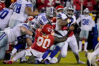 Dallas Cowboys running back Ezekiel Elliott (21) runs with the ball as Kansas City Chiefs defensive tackle Jarran Reed (90) defends during the second half of an NFL football game Sunday, Nov. 21, 2021, in Kansas City, Mo. (AP Photo/Ed Zurga)