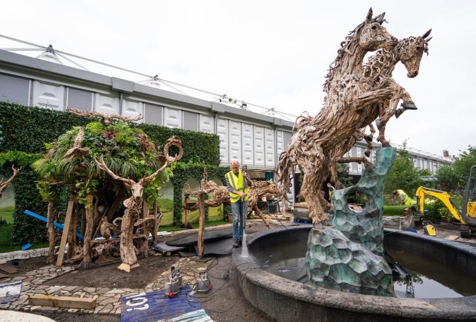 A gardener pressure washes a fountain at the James Doran-Webb Driftwood Sculptures garden ahead of the opening of the flower show (Dominic Lipinski/PA) (PA Wire)