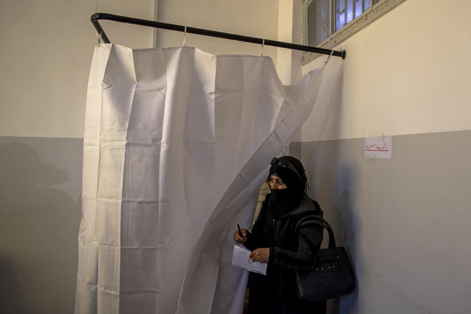 A Syrian woman votes during the Presidential elections, at a polling station in the town of Douma, near the Syrian capital Damascus, Syria, Wednesday, May 26, 2021. Syrians headed to polling stations early Wednesday to vote in the second presidential elections since the deadly conflict began in the Arab country. (AP Photo/Hassan Ammar)