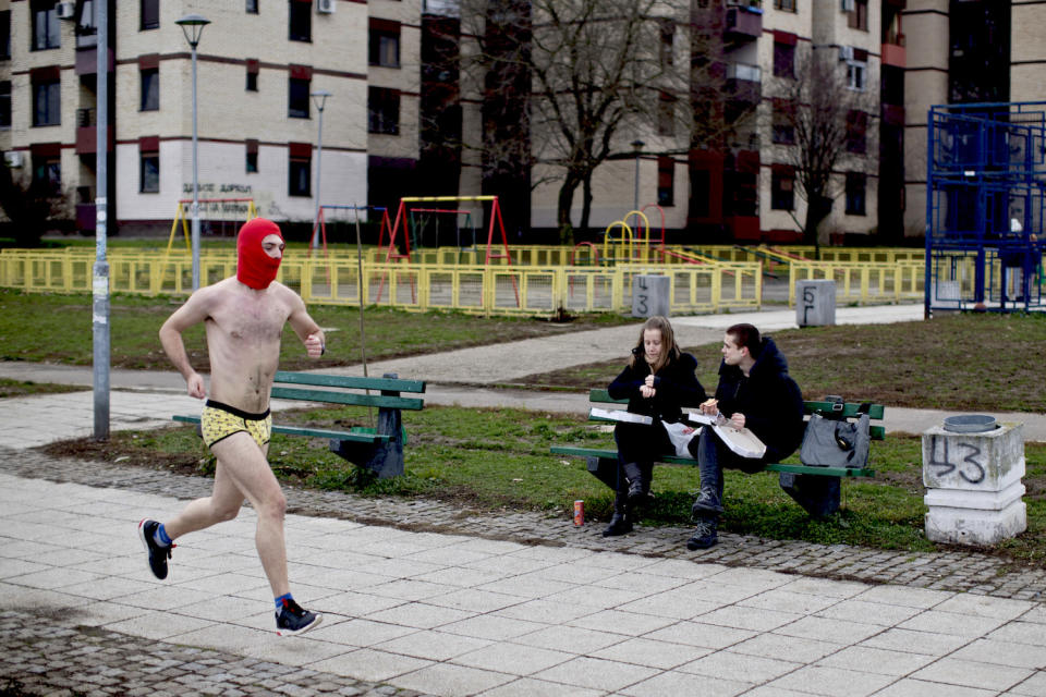 <p>Ein Teilnehmer des 2. Belgrader Unterhosen-Rennens flitzt an zwei jungen Leuten vorbei, die es sich auf einer Bank bequem gemacht haben. (Bild: AP Photo/Marko Drobnjakovic) </p>