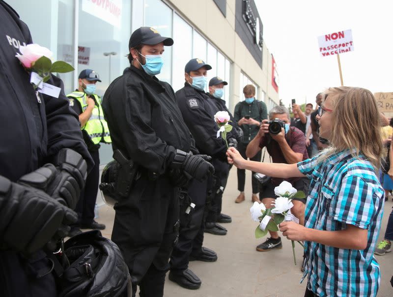 FILE PHOTO: Riot police stand in front of the entrance to an Econofitness gym as people gather to protest their use of a vaccine passport, in Laval, Quebec